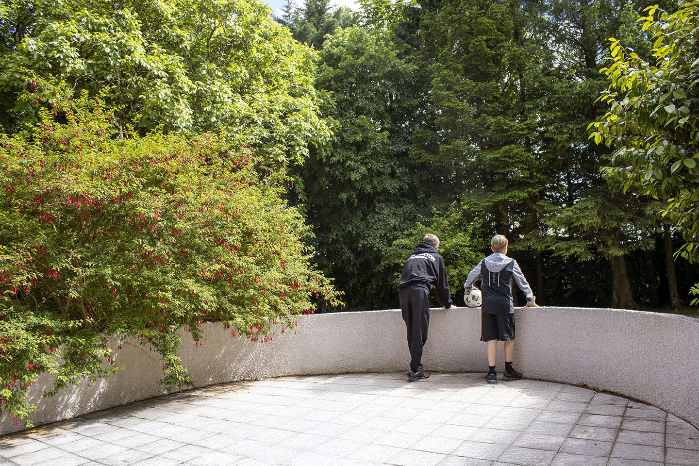 2 young boys overlooking the garden on the patio